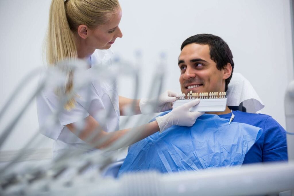 A dentist showing a patient different tooth shade options for cosmetic treatment.