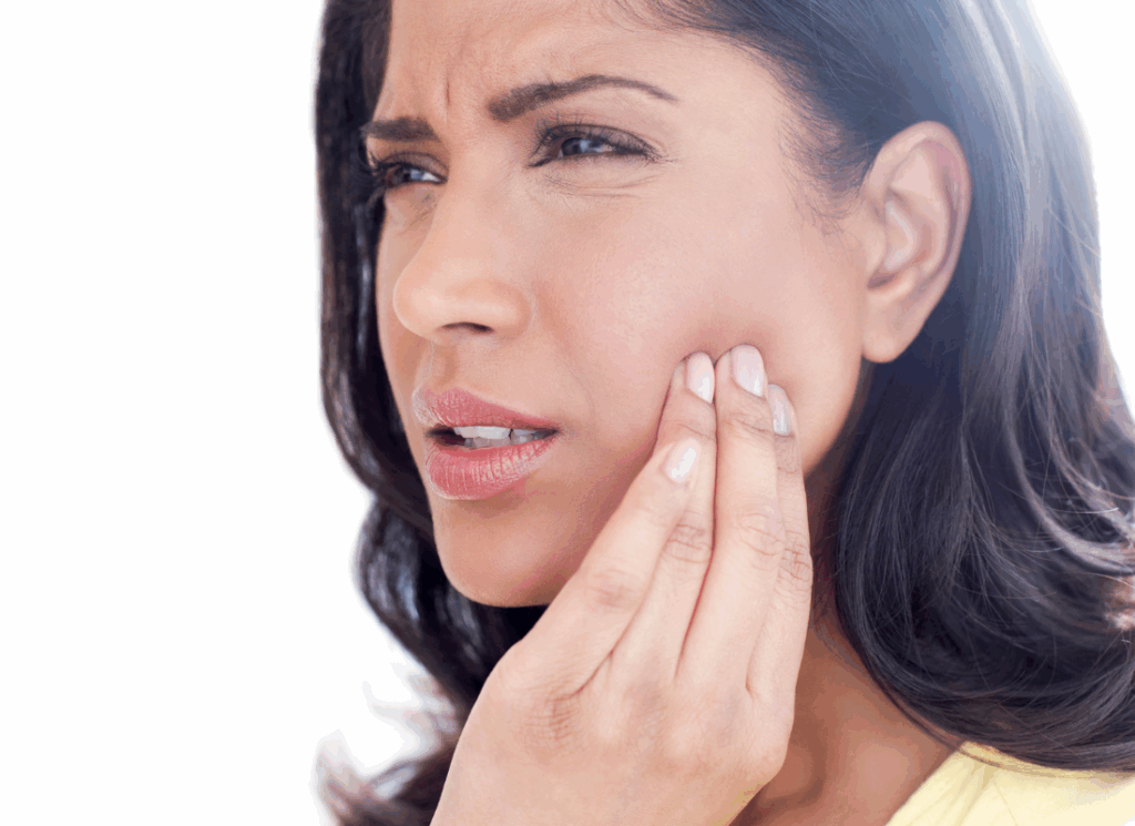 A woman touching her jaw and showing discomfort from TMJ pain.