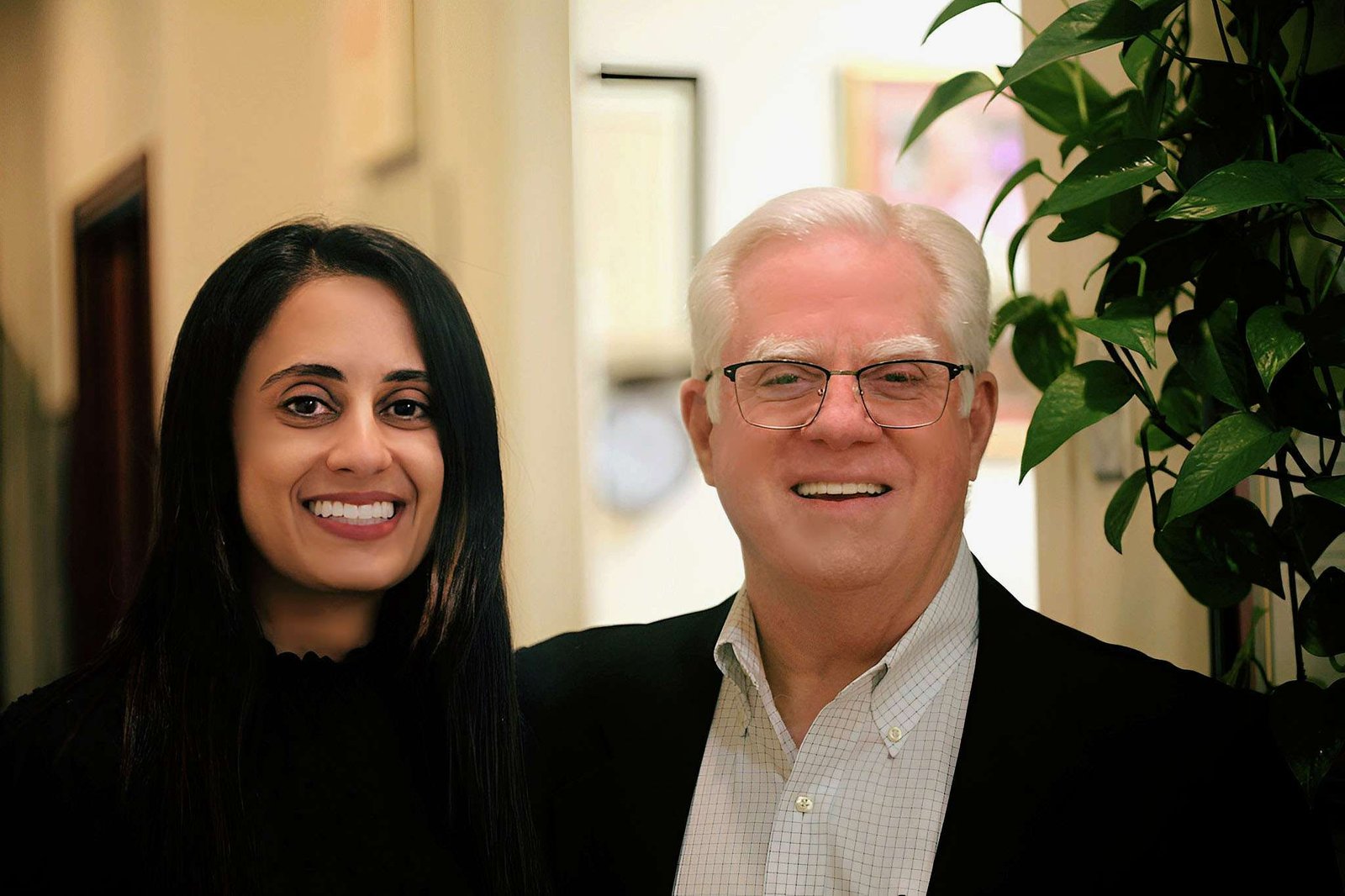 Dr. Priya and Dr. Peppard smiling together inside the dental office.
