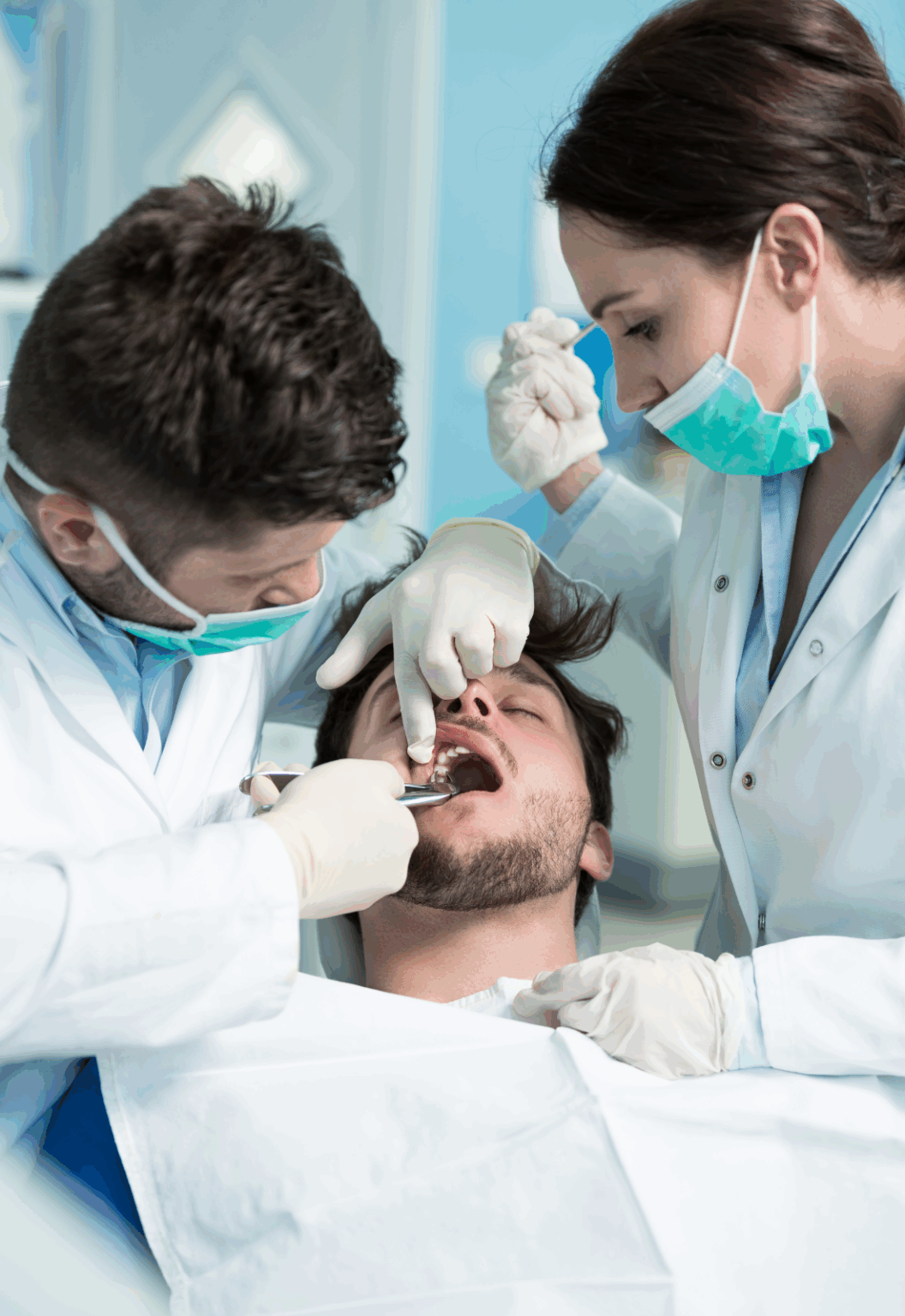 Dentists performing a tooth extraction on a patient.