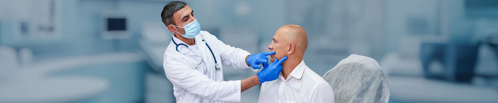 A doctor examining a man's jaw for TMJ issues.