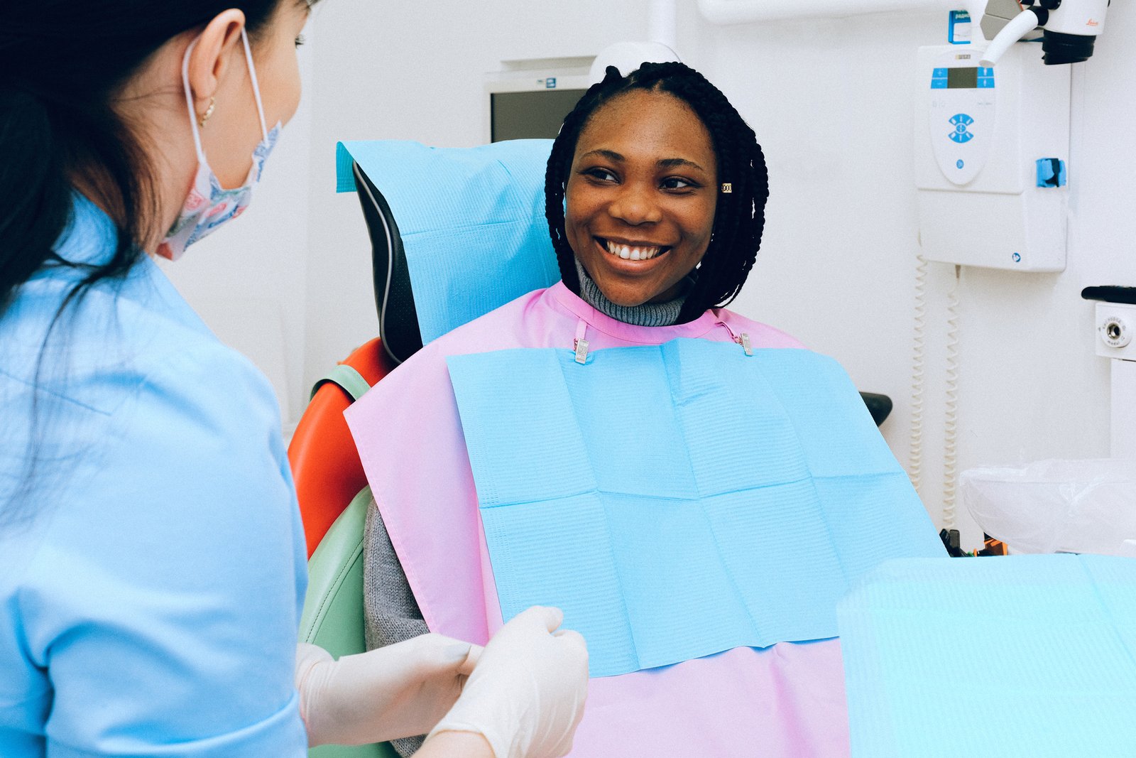 A smiling patient sitting in a dental chair during a consultation.