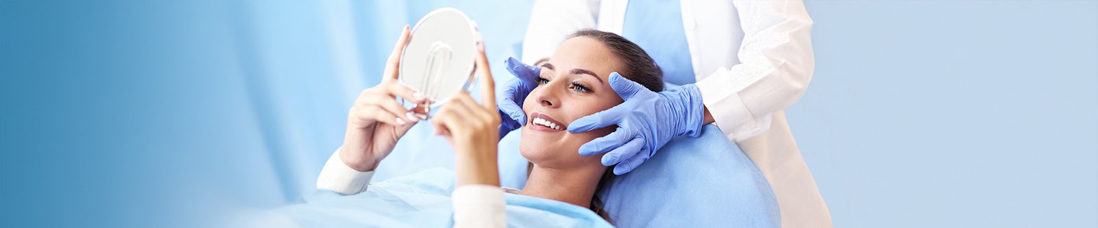 A smiling woman looking in a mirror after a dental bonding treatment.